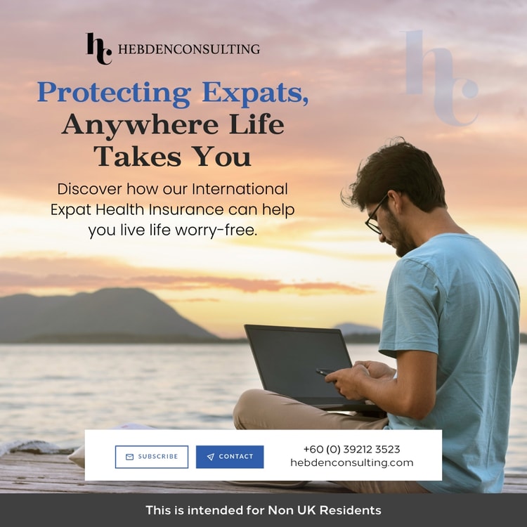 A man sitting on a dock using a laptop computer
