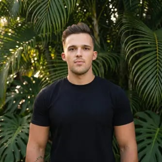 A man in a black shirt standing in front of trees