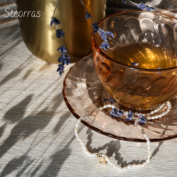 A glass cup of tea on a saucer