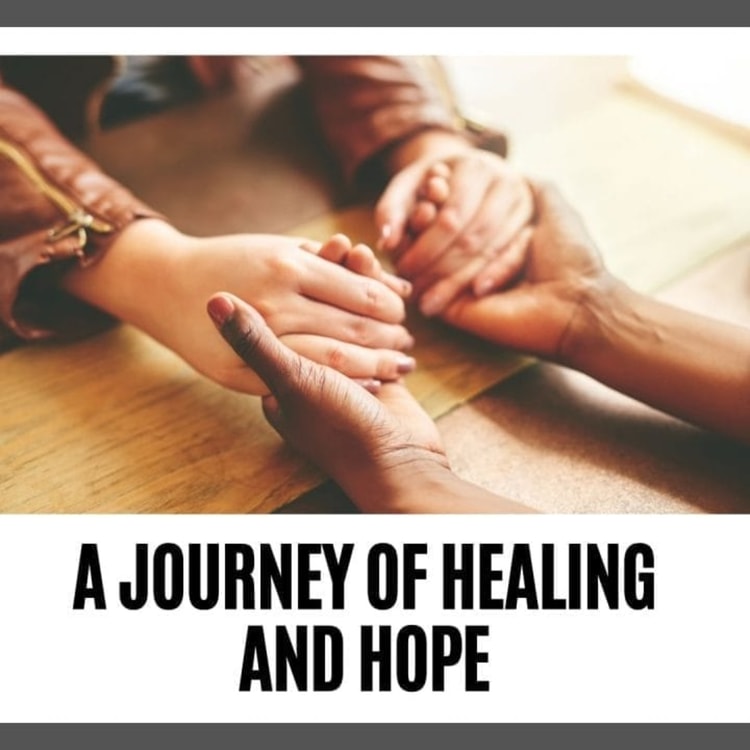 A group of people holding hands over a wooden table