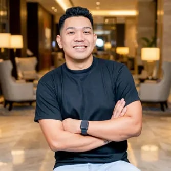 A man with his arms crossed sitting in a lobby