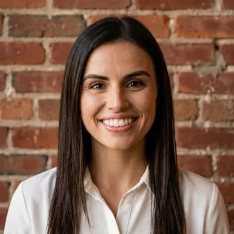 A woman smiling in front of a brick wall