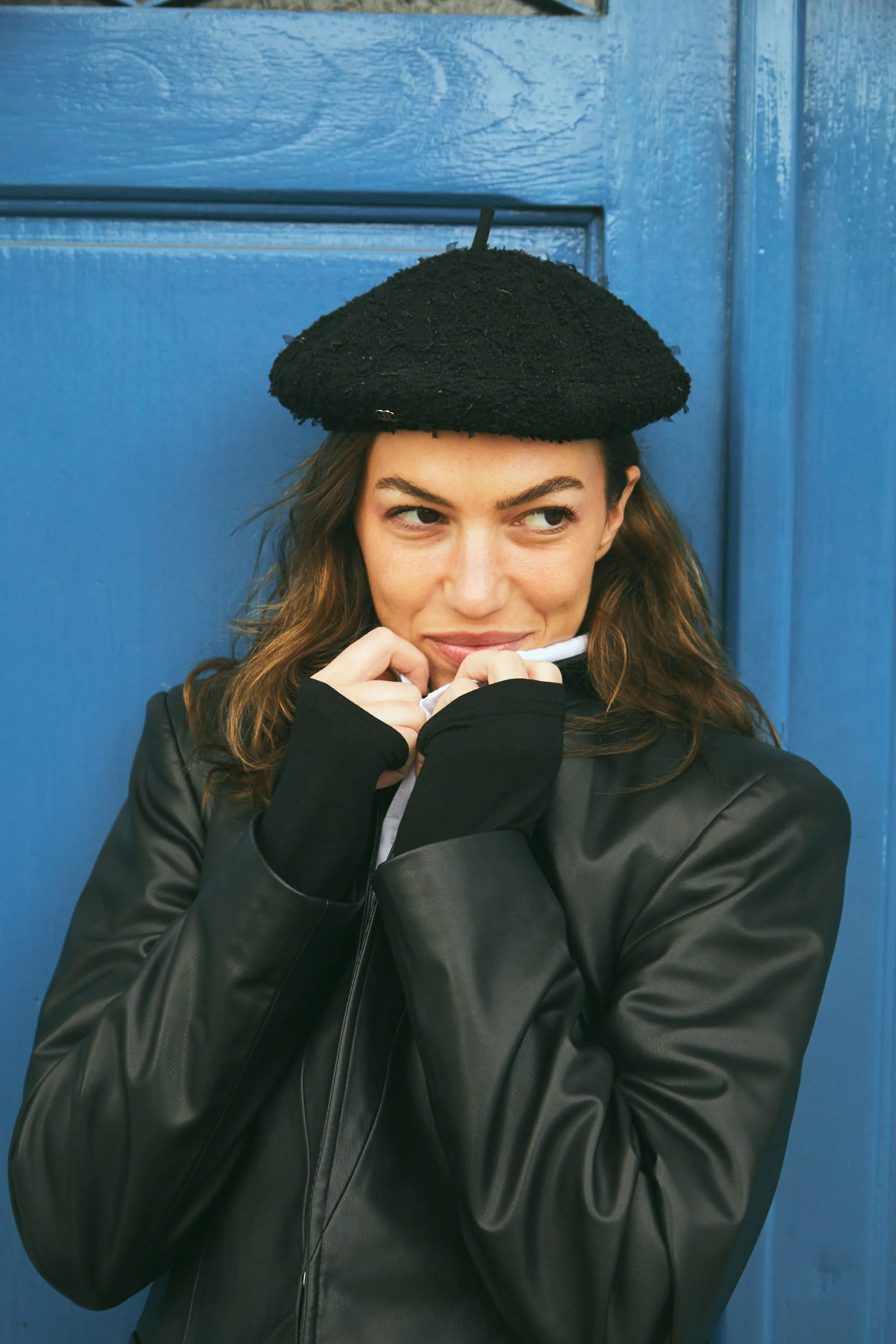 A woman wearing a black hat and a black jacket