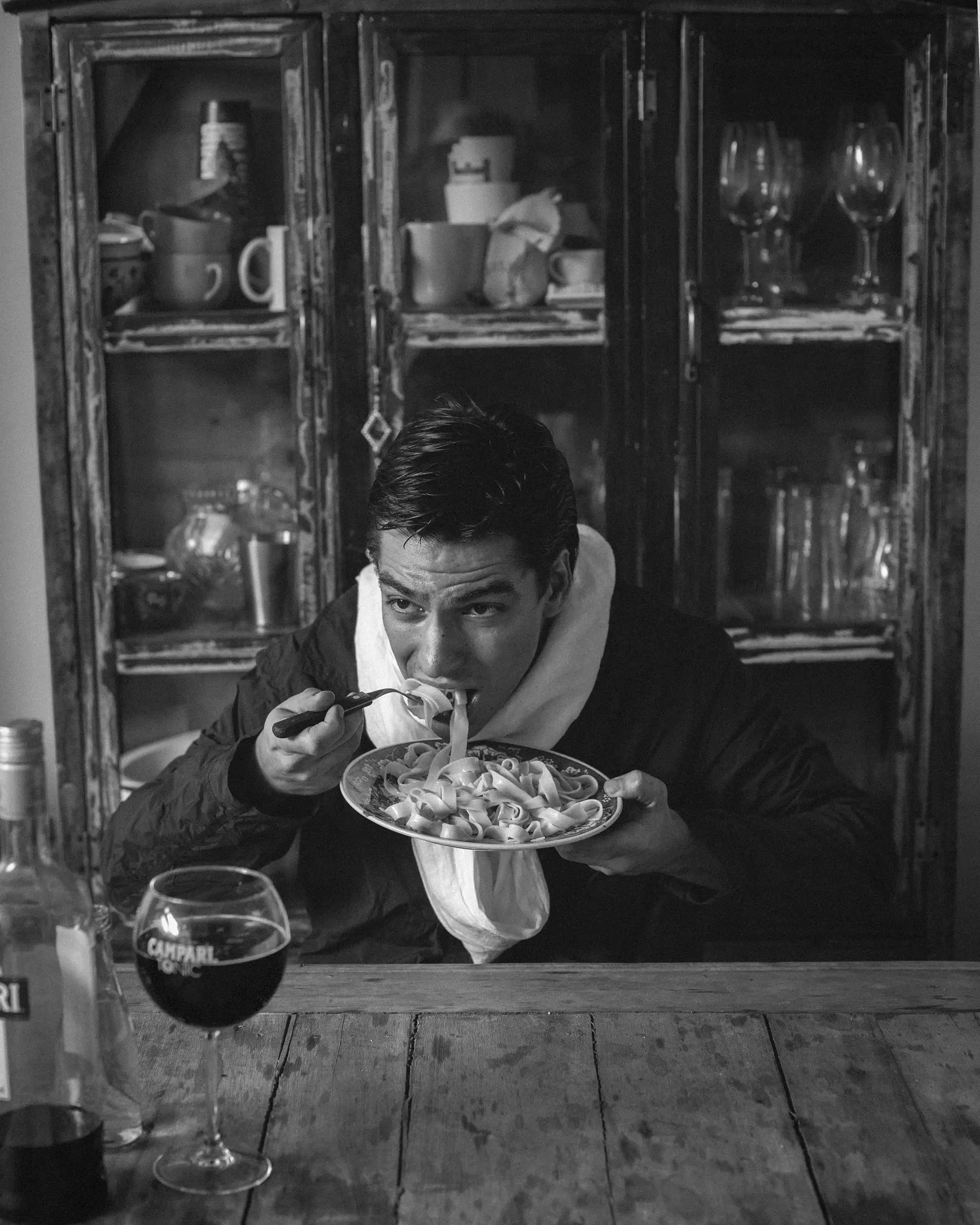 A man sitting at a table eating a plate of food
