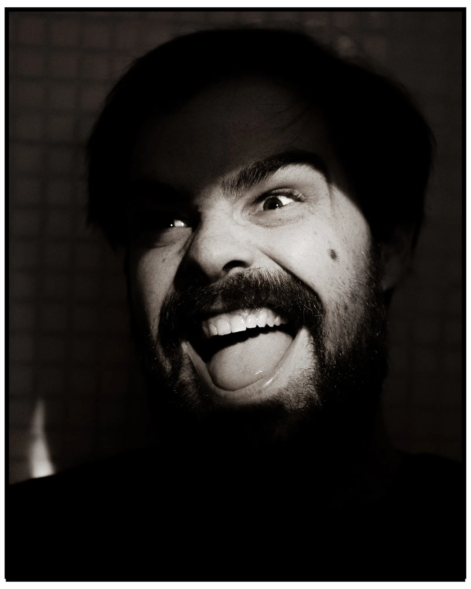 A black and white photo of a man smiling