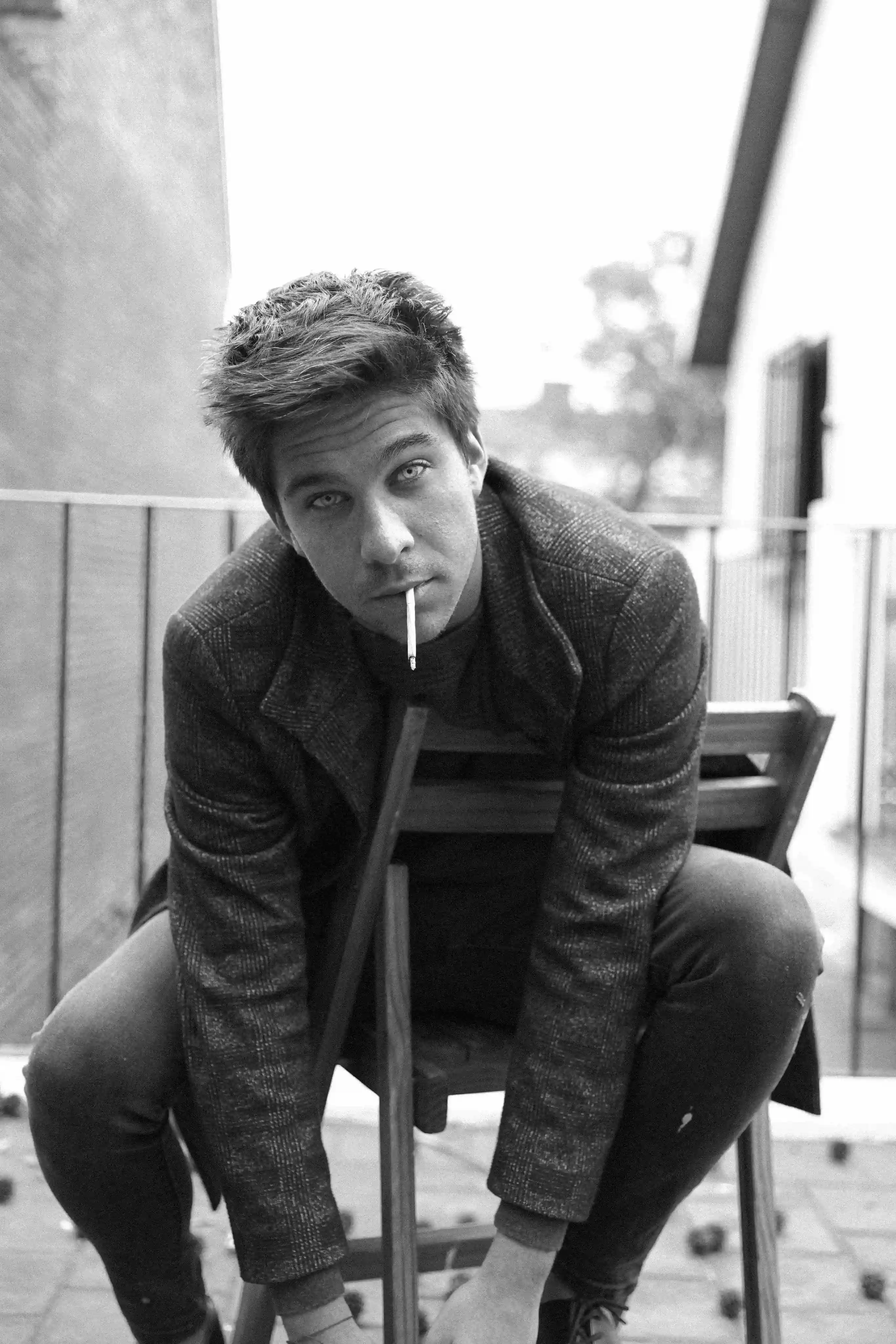 A man sitting on a chair smoking a cigarette