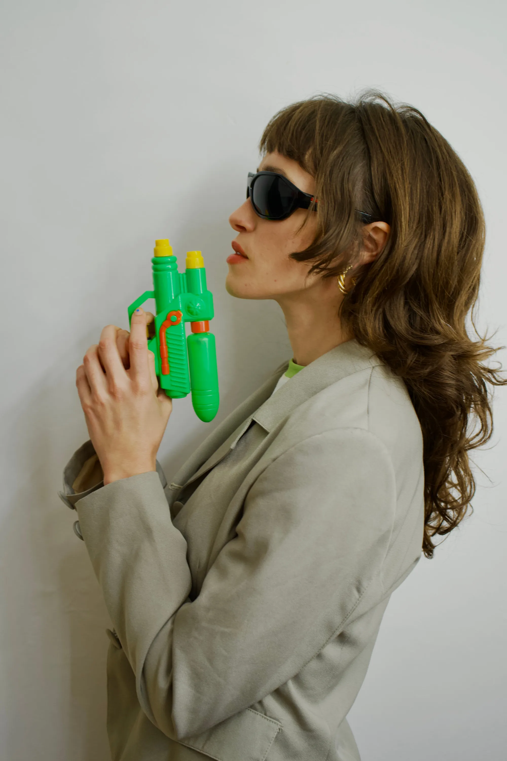 A woman holding a green and yellow toy gun