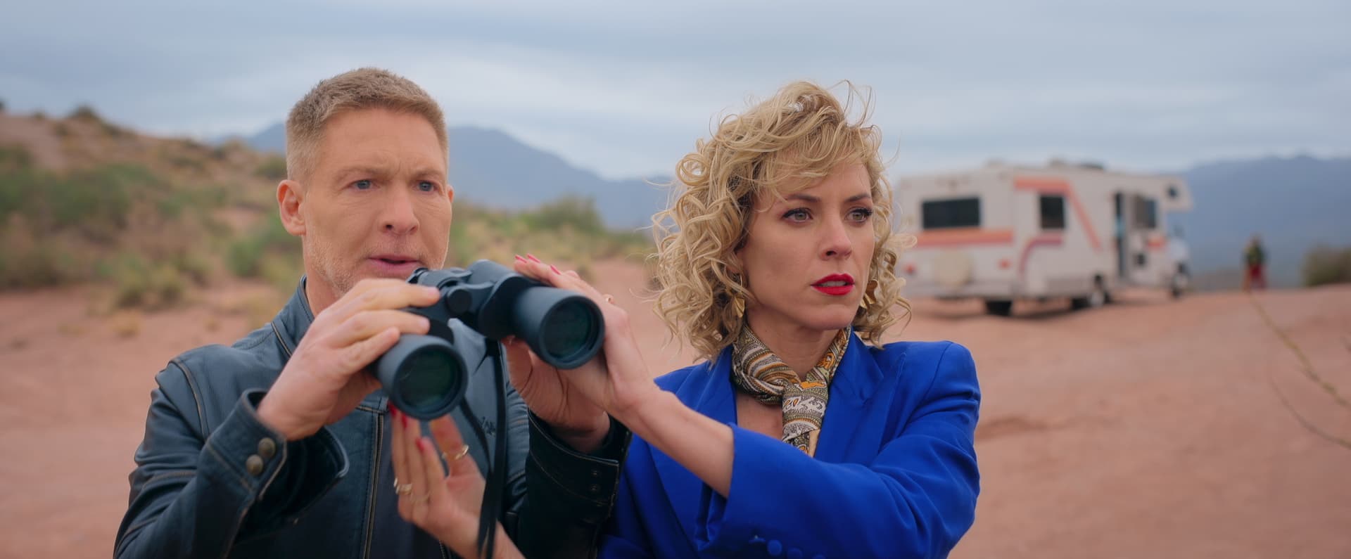 A man and a woman looking through binoculars