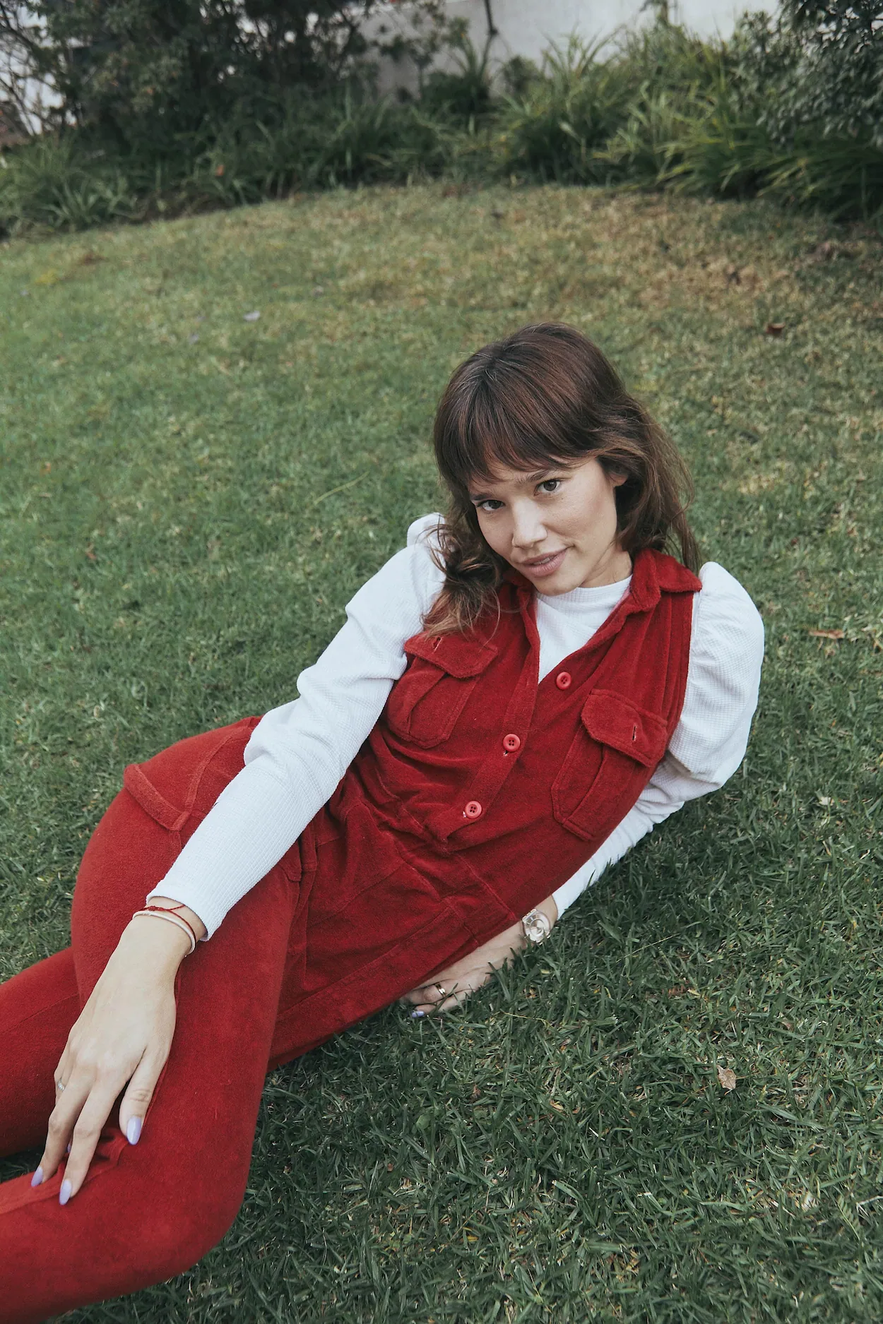 A woman sitting on the grass in a red dress