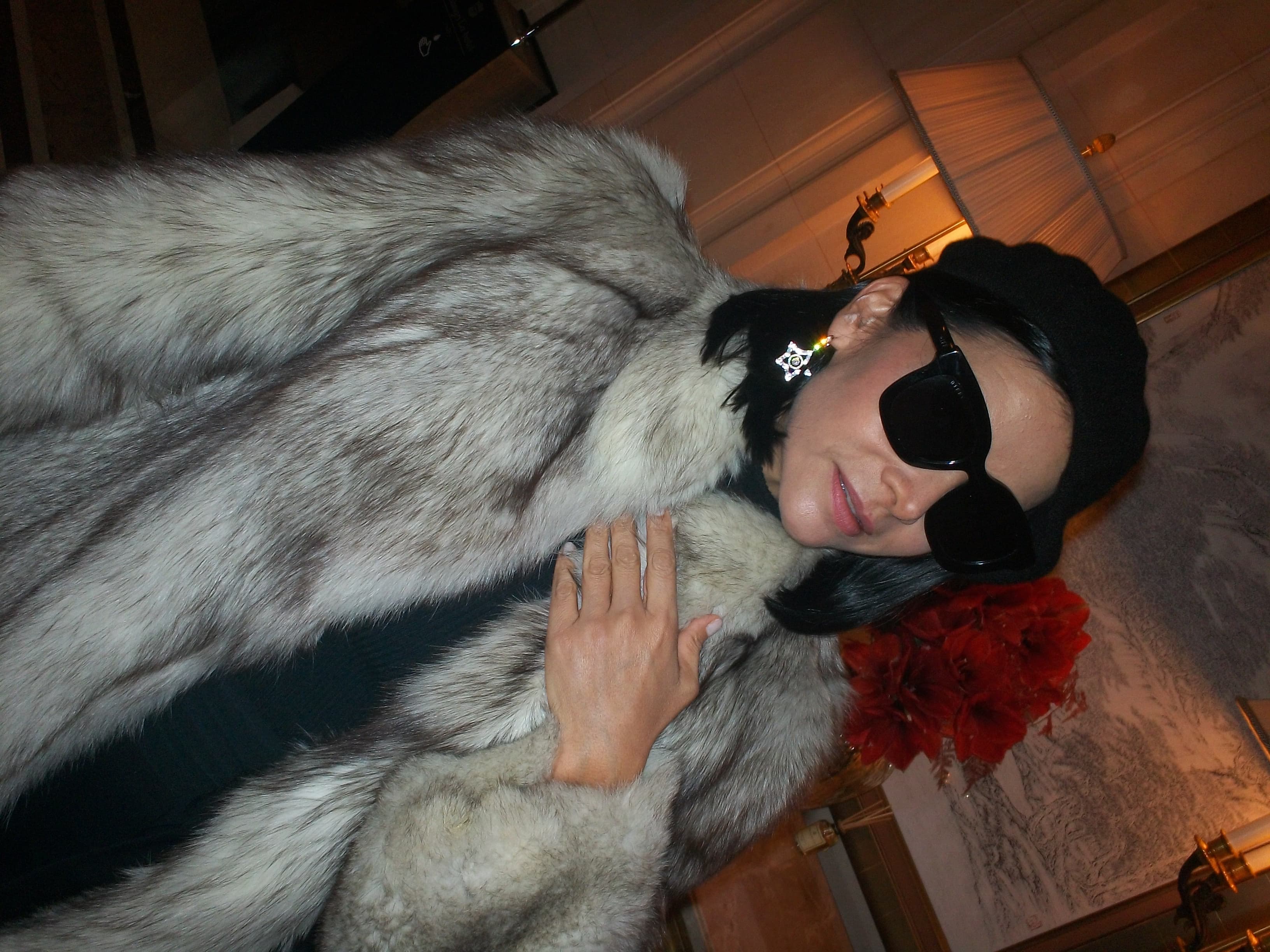 A woman wearing sunglasses and a fur coat