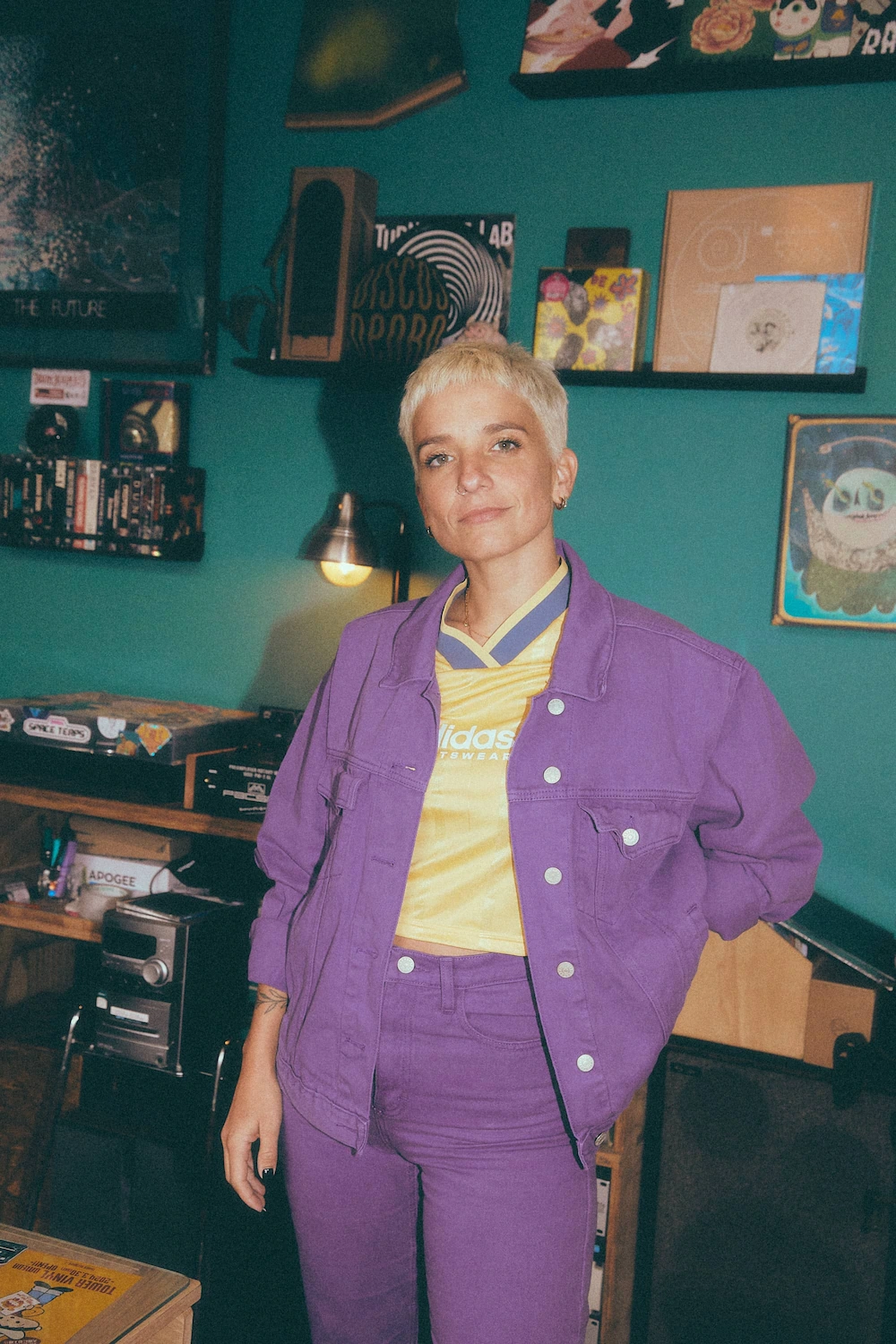 A woman in a purple jacket standing in a room