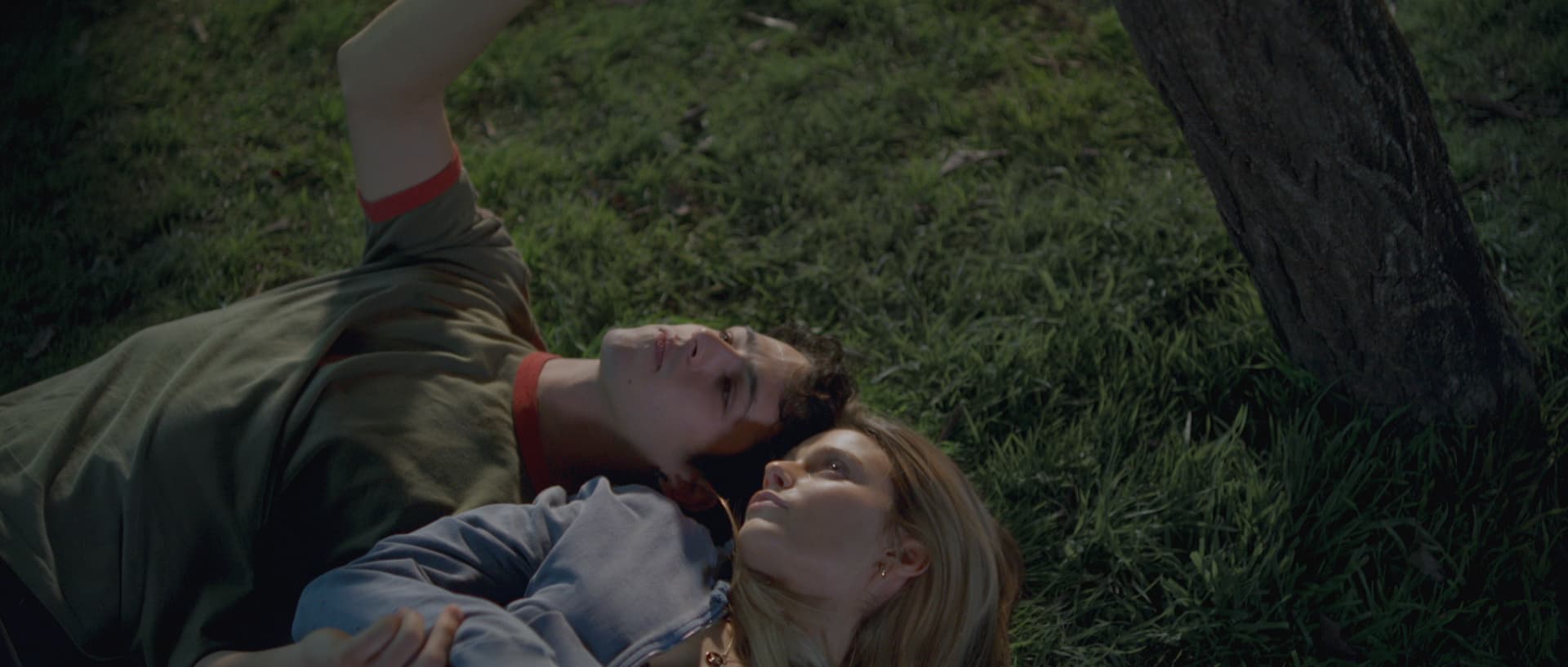 A woman laying on the ground next to a man