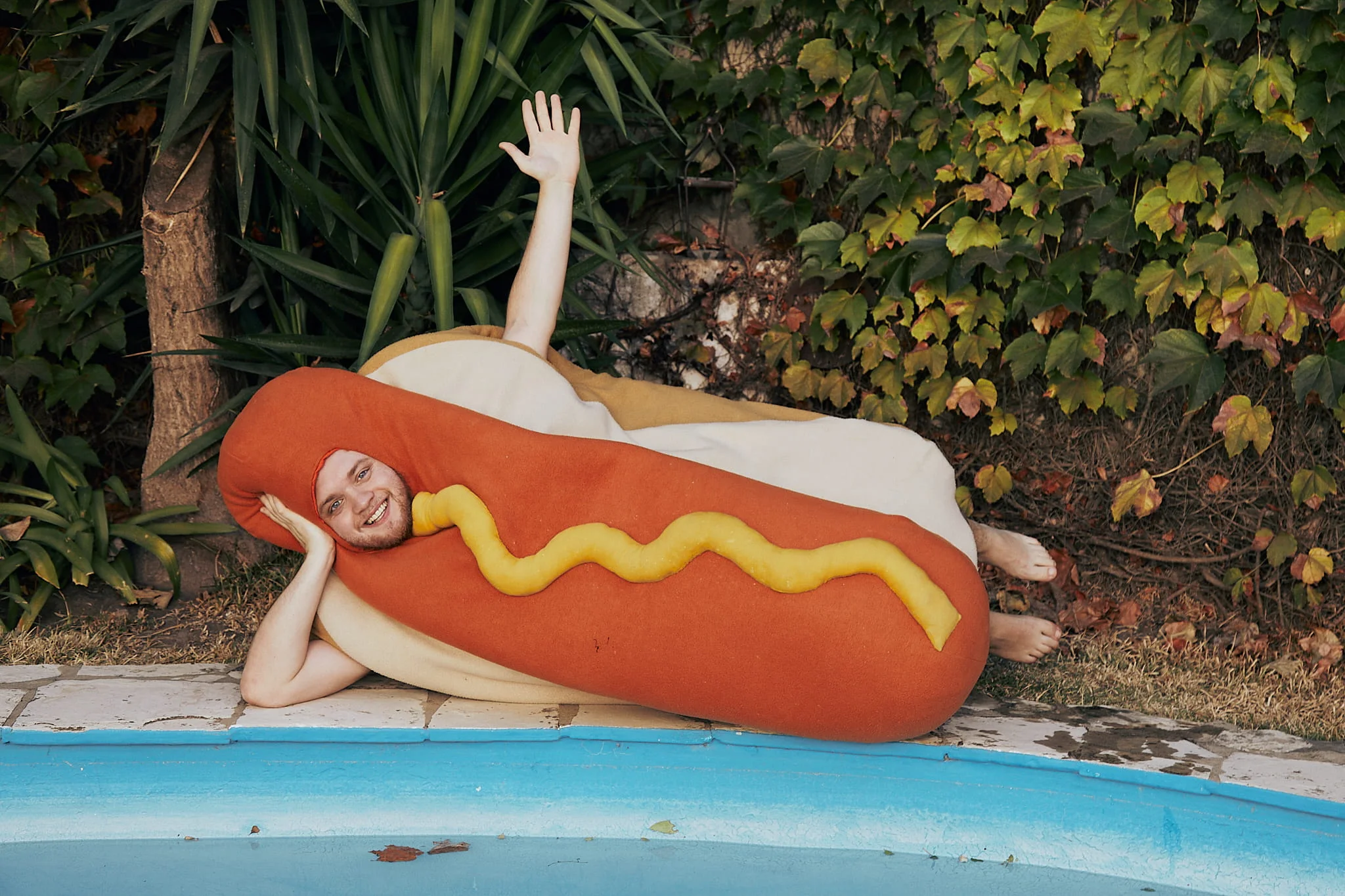 A person laying on a hot dog in a pool