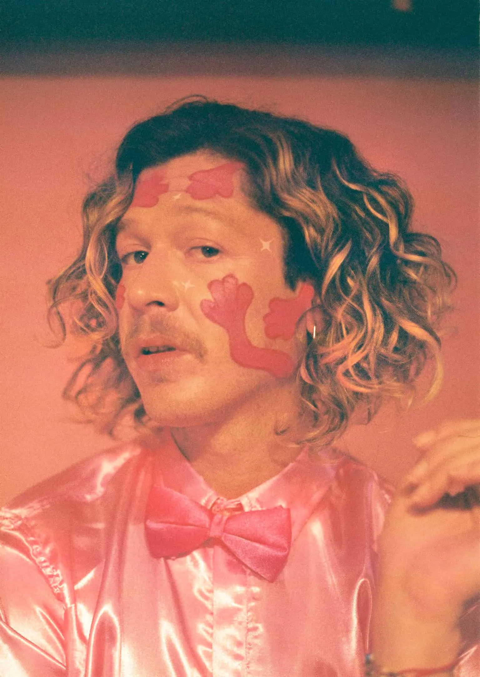 A man wearing a pink shirt and bow tie