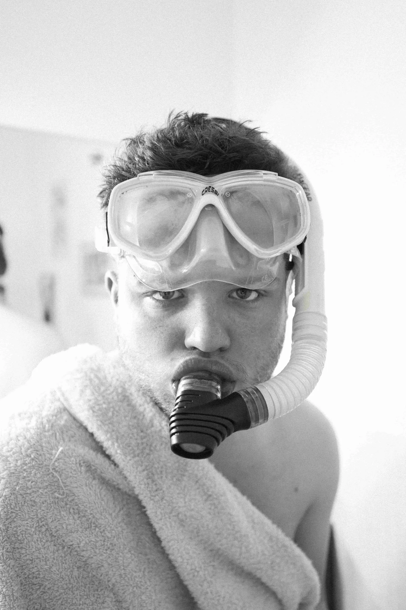 A man in a bathrobe with a mask and goggles on