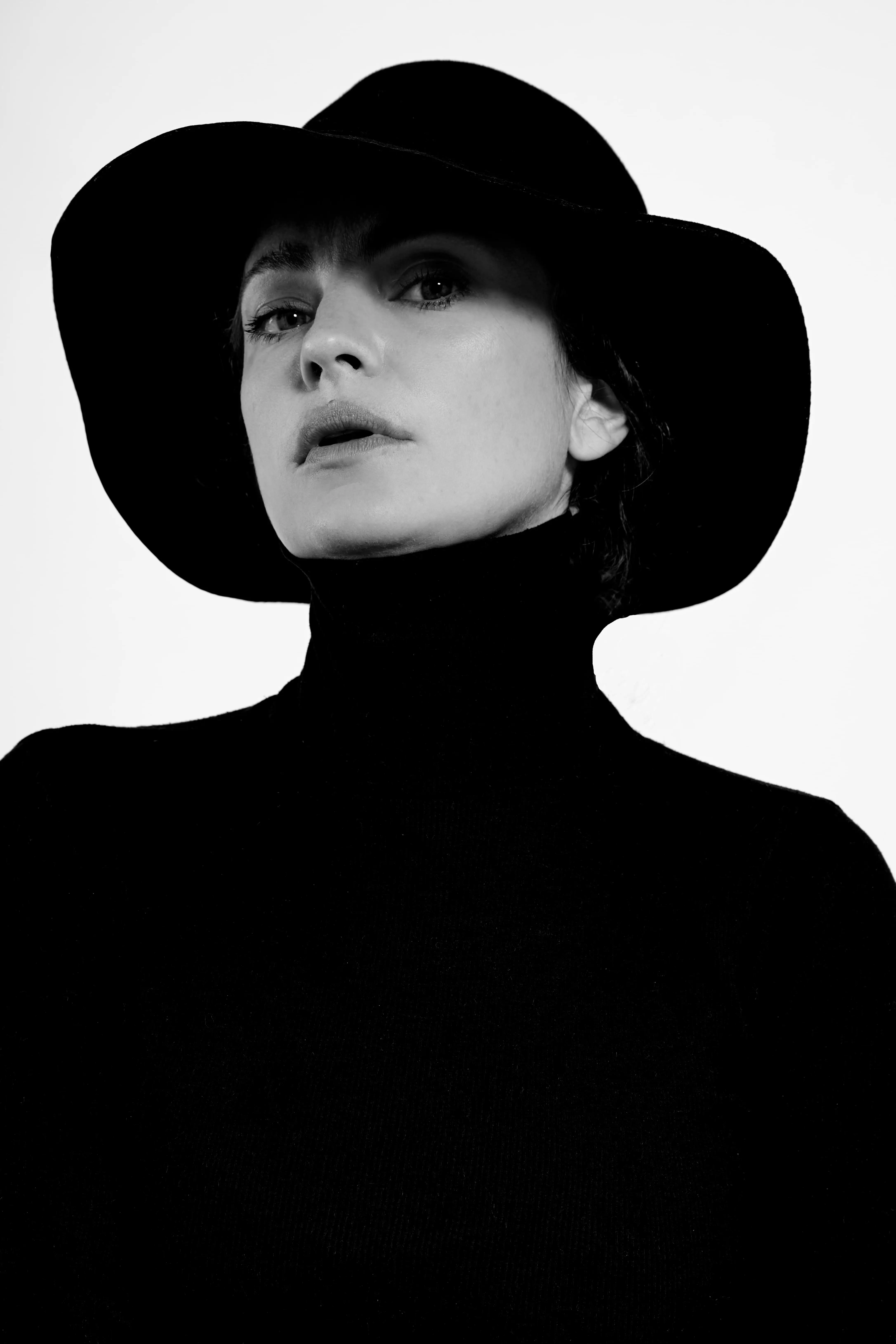 A woman wearing a black hat and black dress