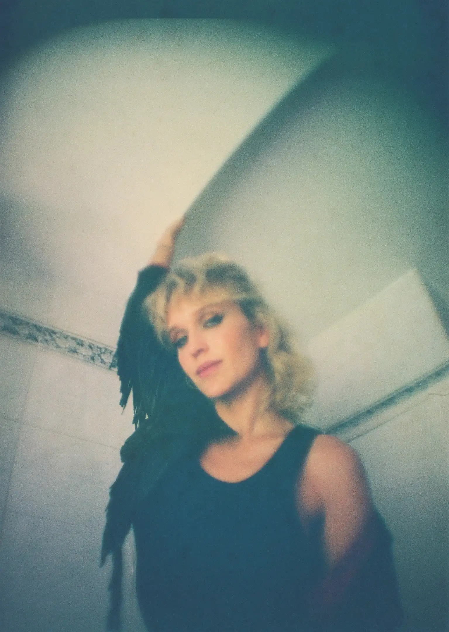A woman standing in front of a white wall