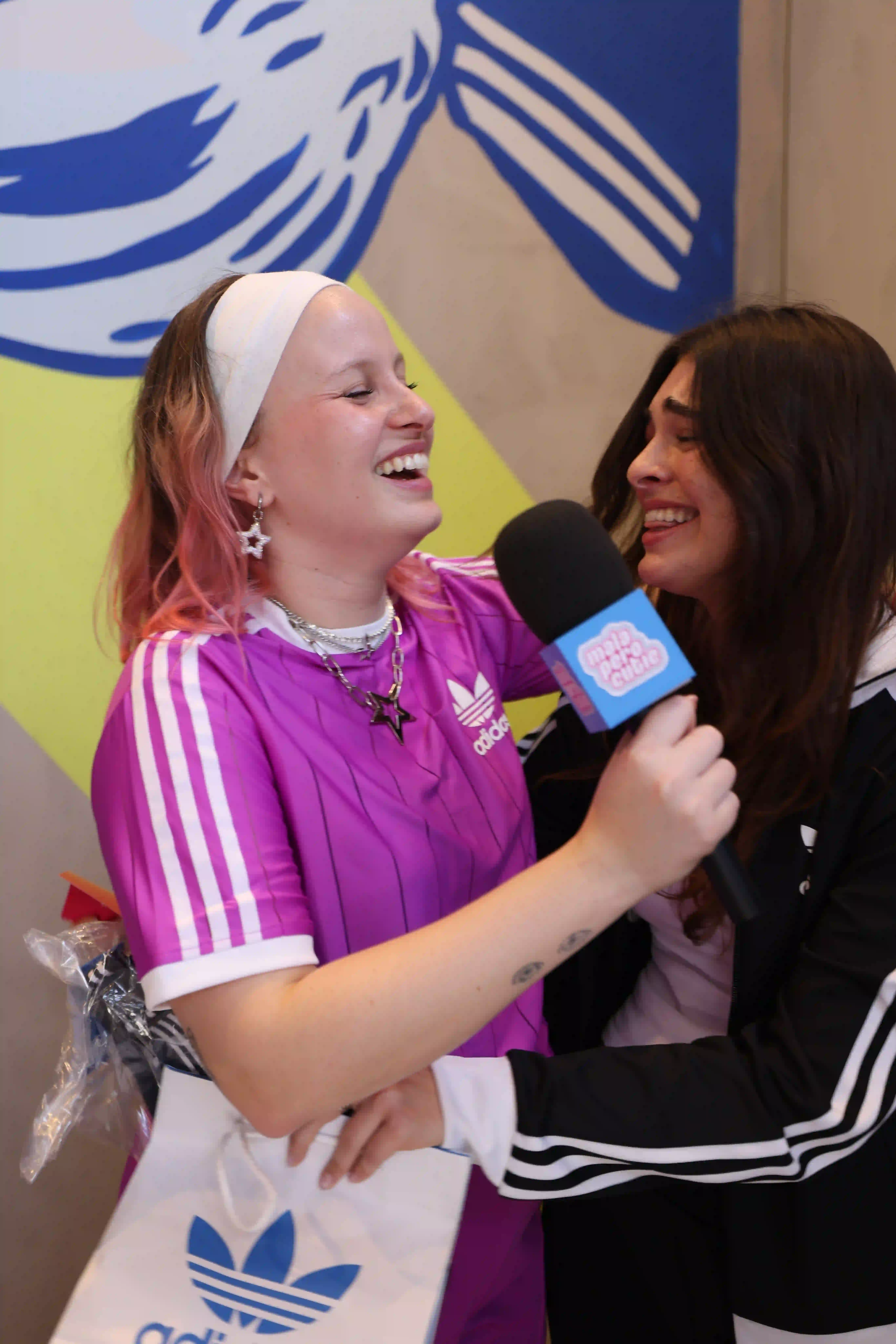 A woman holding a microphone and talking to another woman
