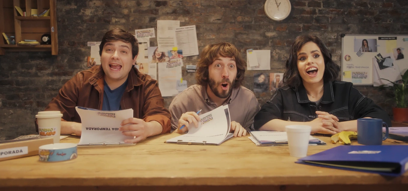 Three people sitting at a table with papers in front of them