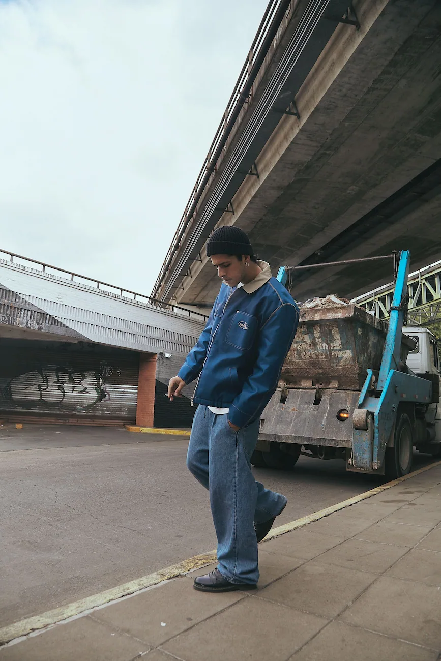 A man standing on a sidewalk next to a truck