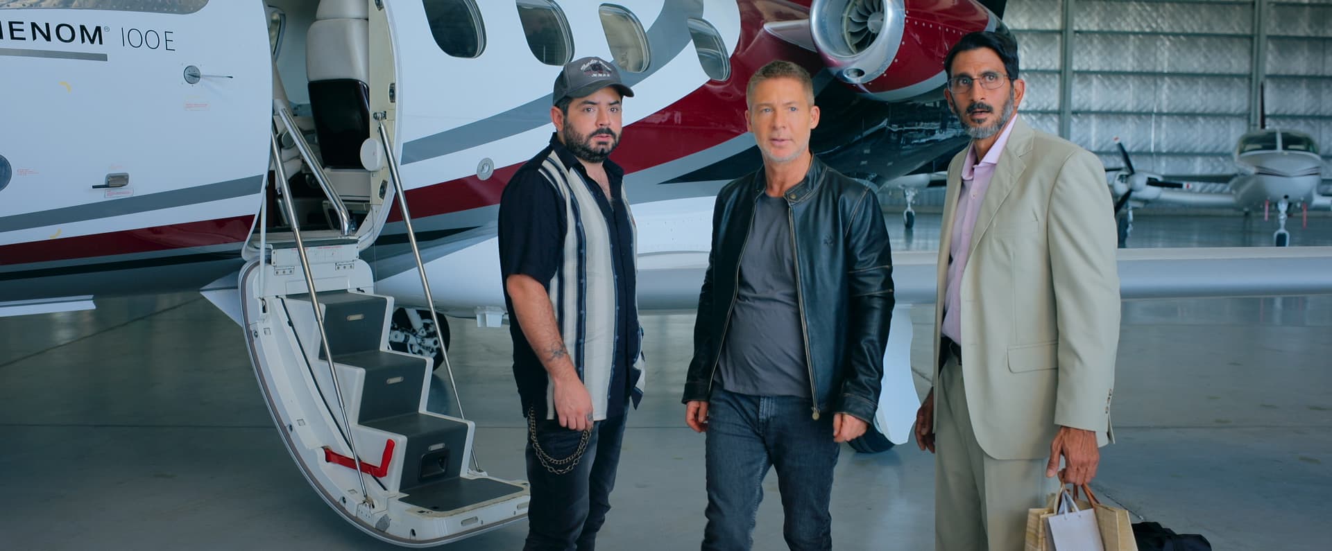 Three men standing in front of an airplane
