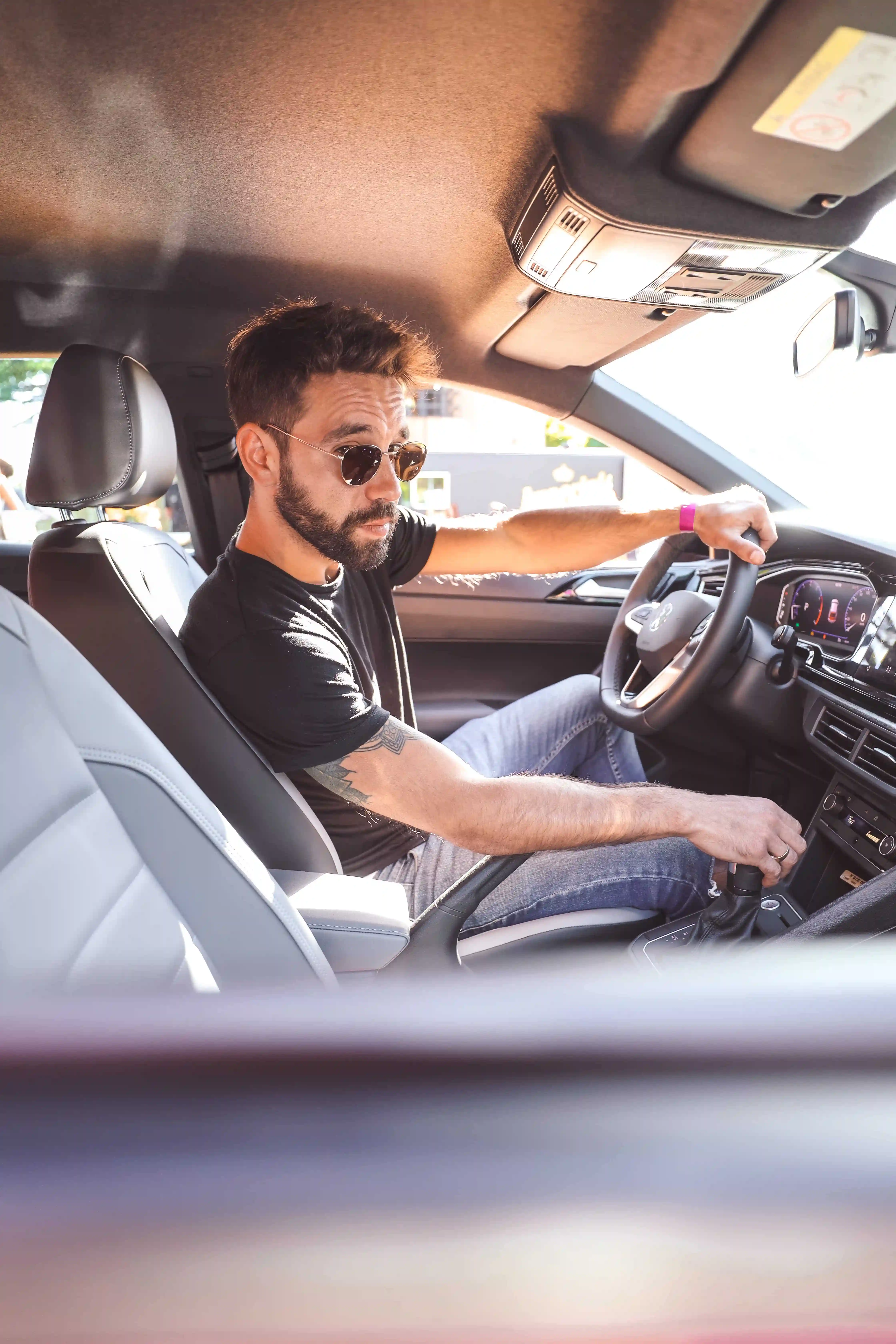 A man driving a car with a steering wheel