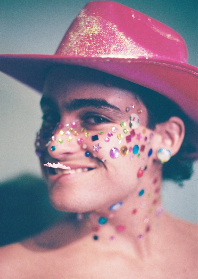 A man wearing a pink hat and face paint