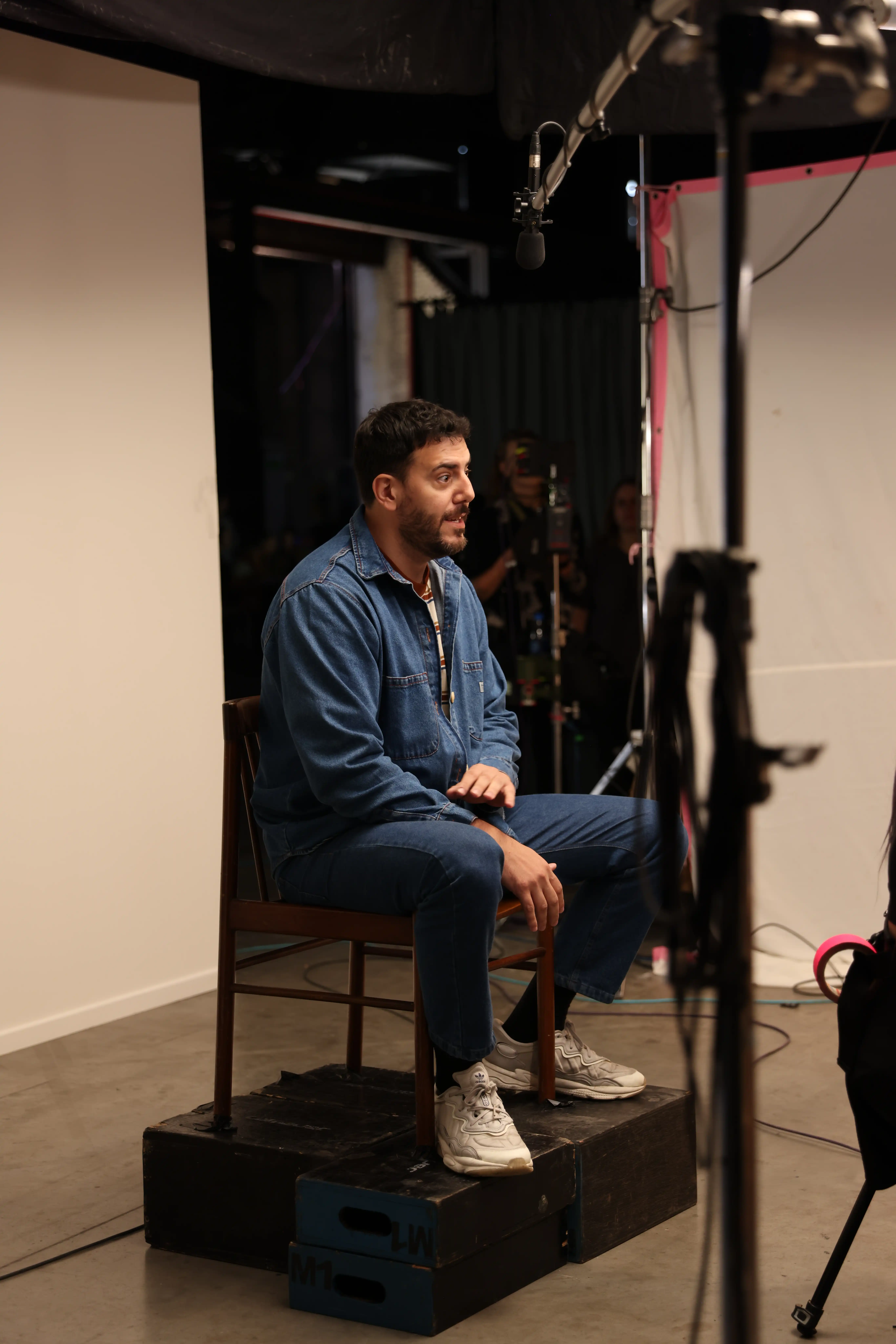 A man sitting in a chair in front of a camera