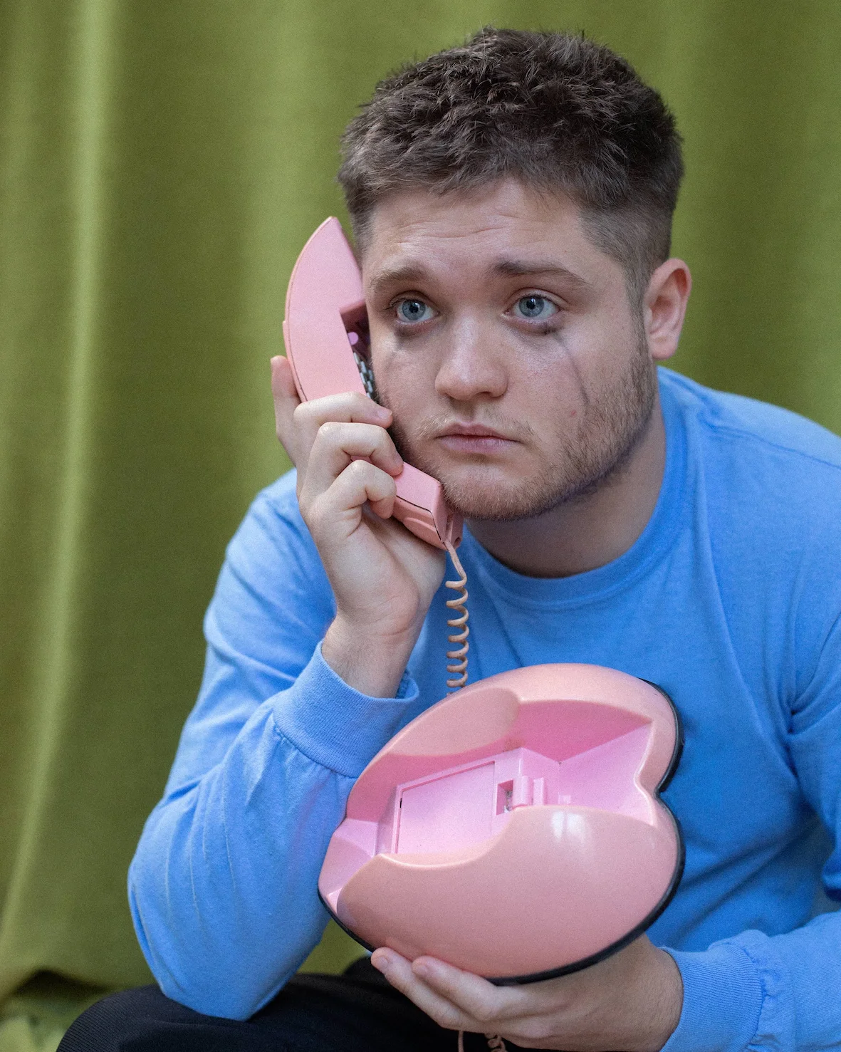 A man holding a pink phone up to his face