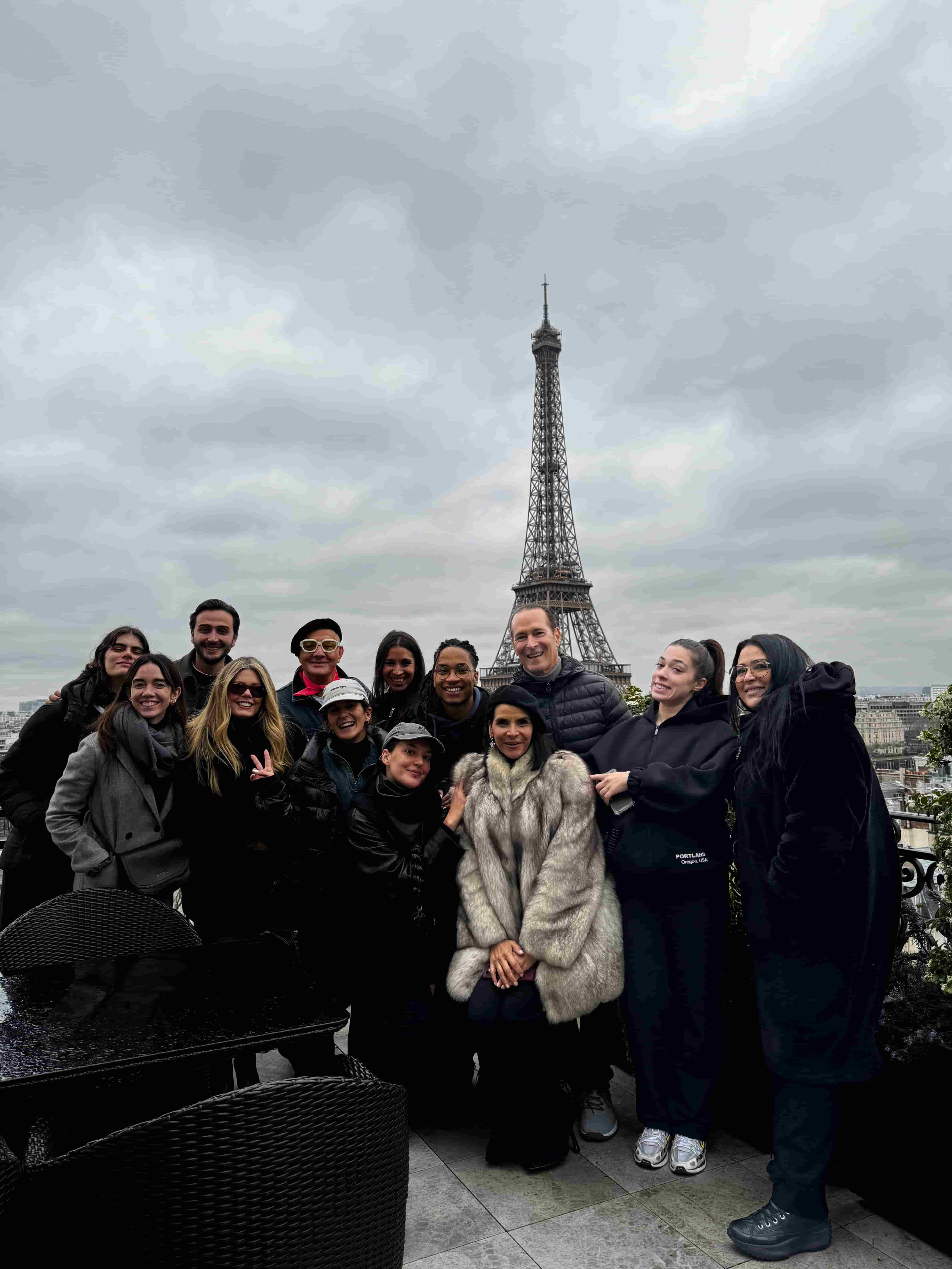 A group of people posing for a picture in front of the eiffel tower