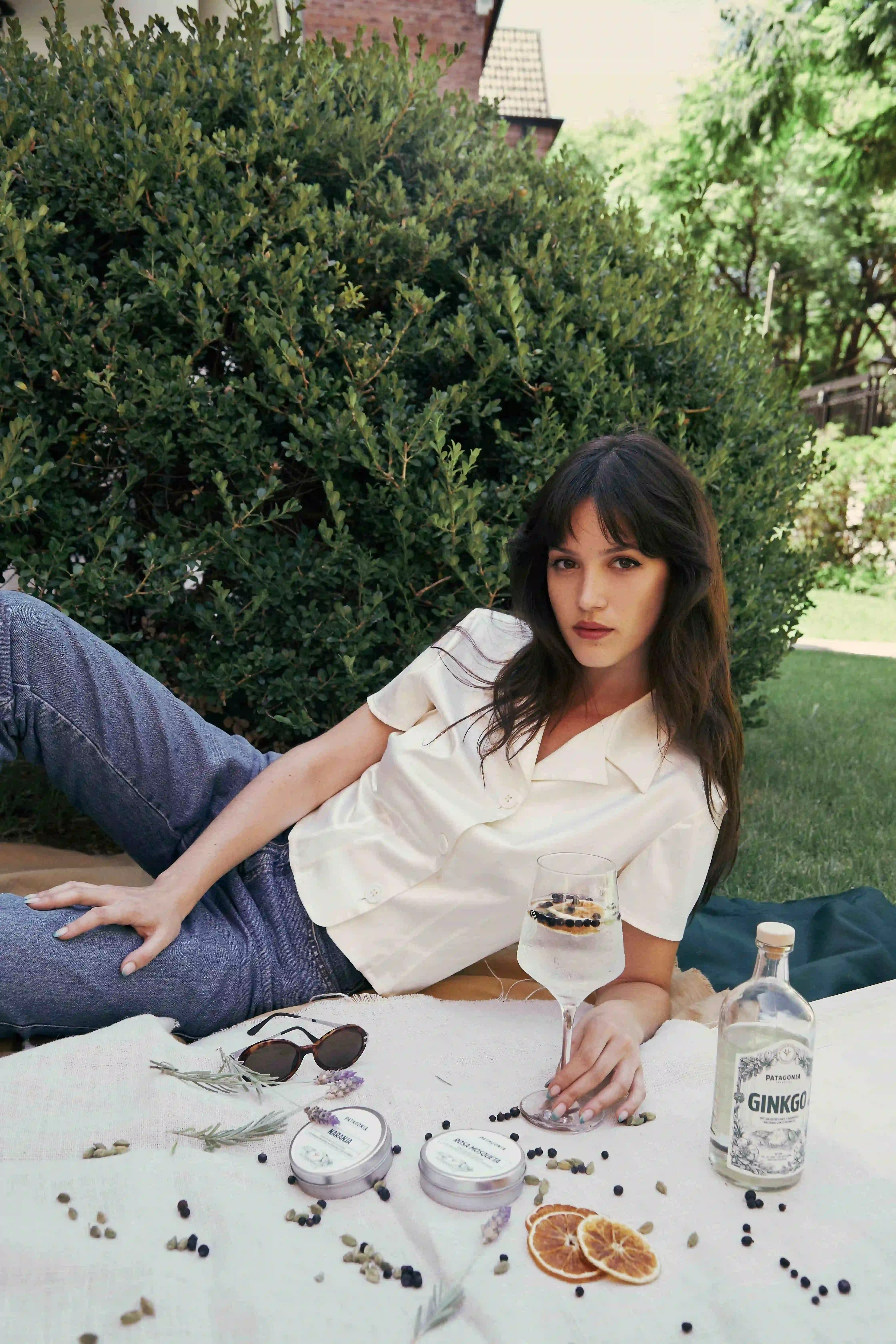 A woman sitting on a table with a bottle of booze