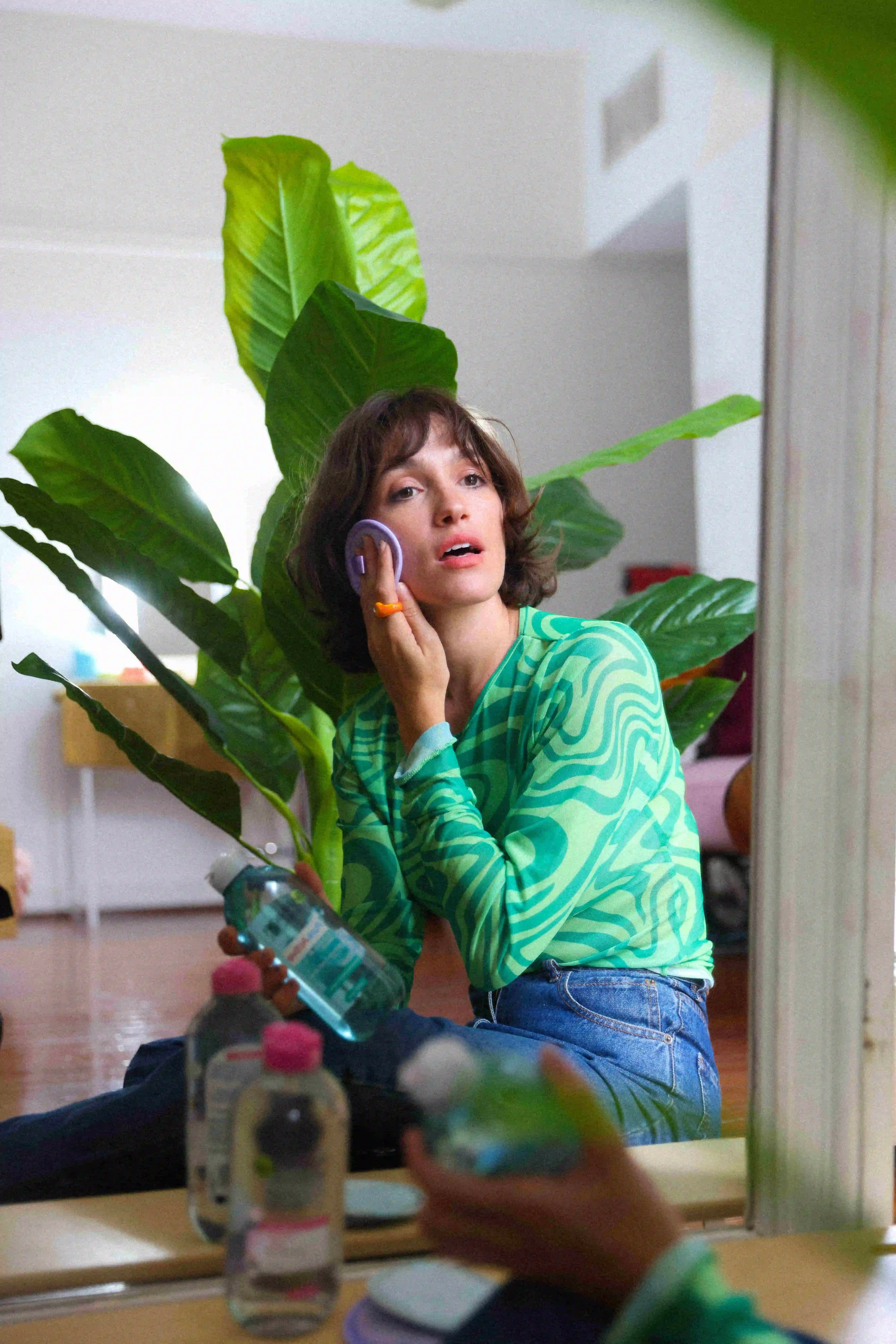 A woman sitting on the floor talking on a cell phone