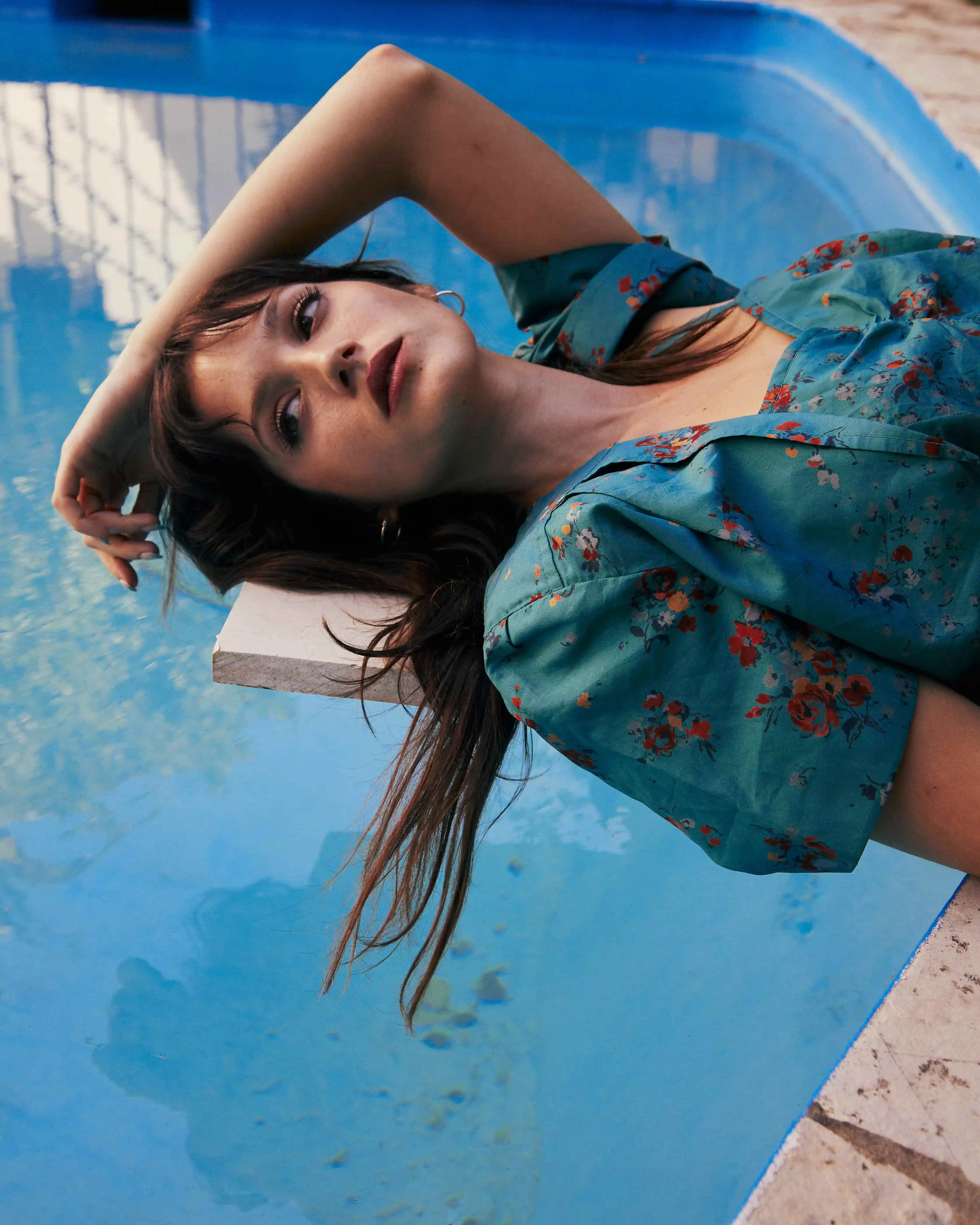 A woman laying on a ledge in a pool