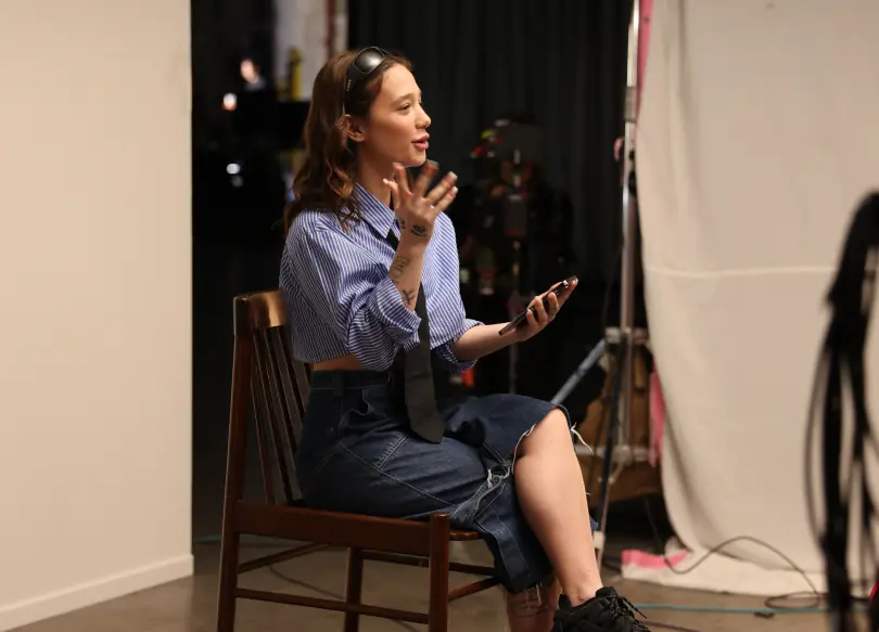 A woman sitting in a chair in front of a camera