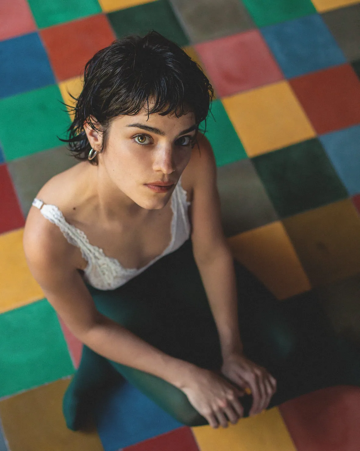 A woman is sitting on a colorful floor