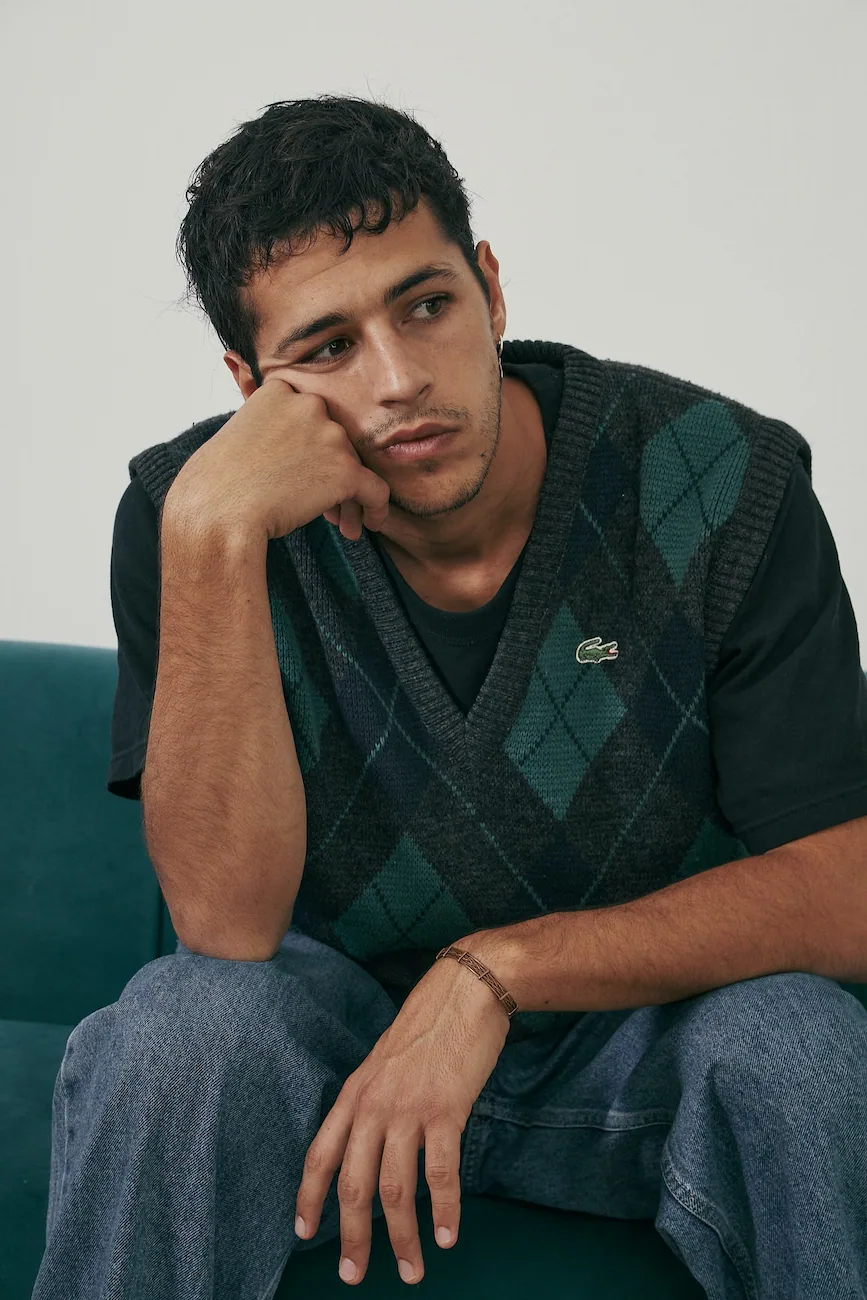 A man sitting on top of a green couch