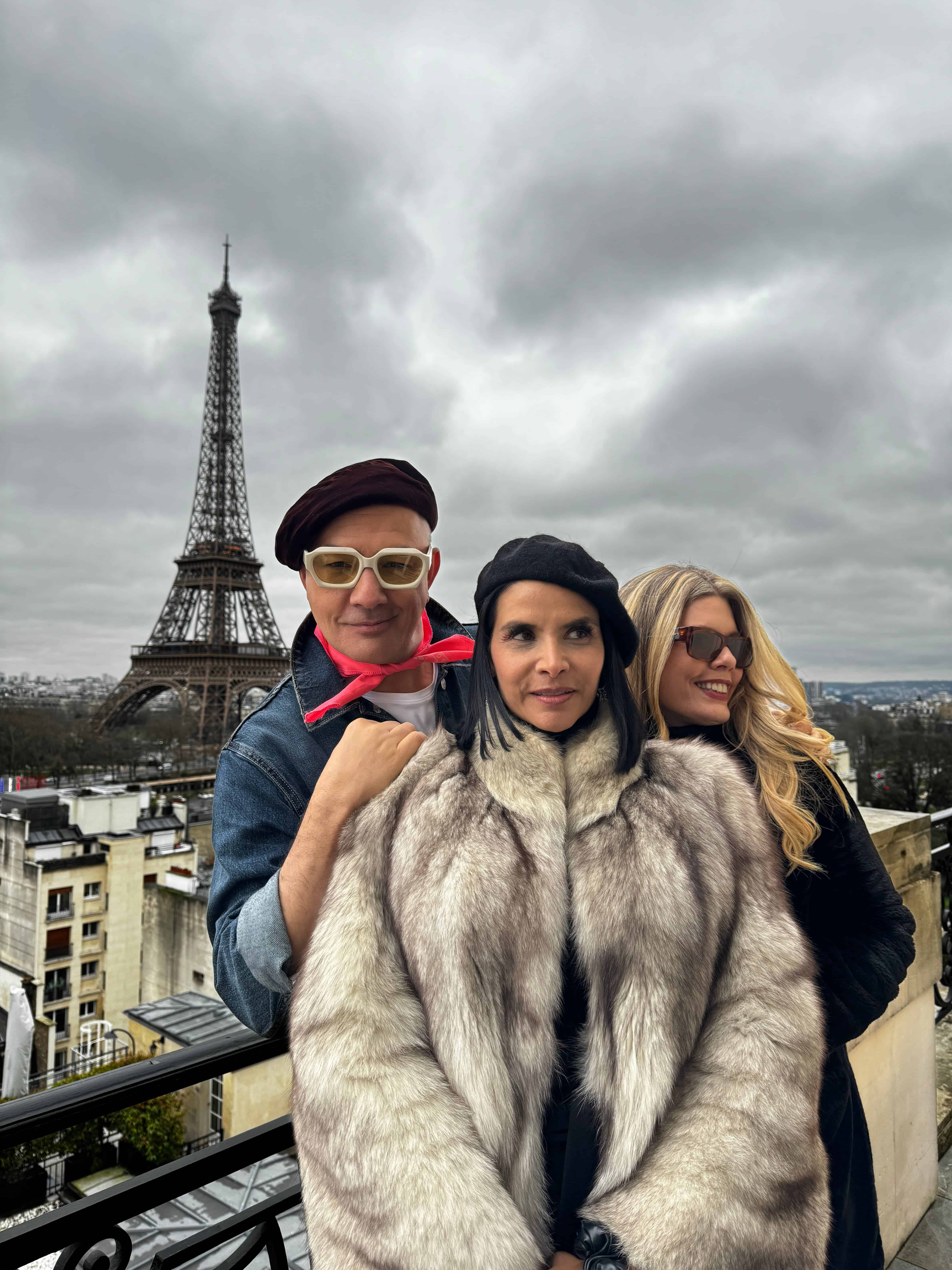 A man and a woman posing for a picture in front of the eiffel