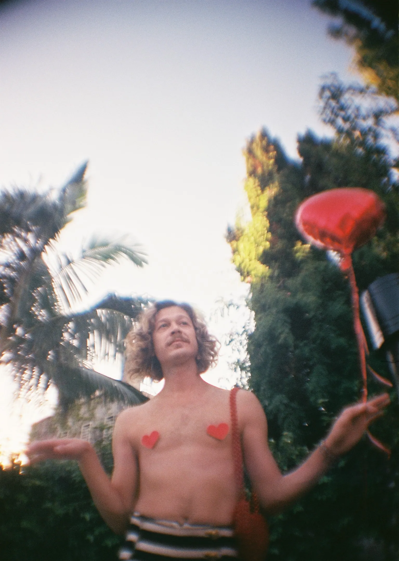 A man with no shirt holding a frisbee
