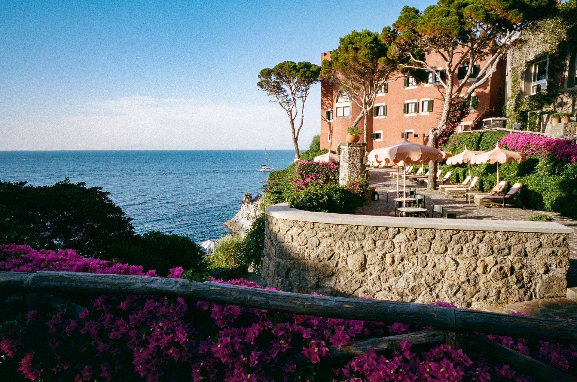 mezzatorre-hotel-and-thermal-spa-exterior-pink-sunbeds-pink-umbrellas-sea-view