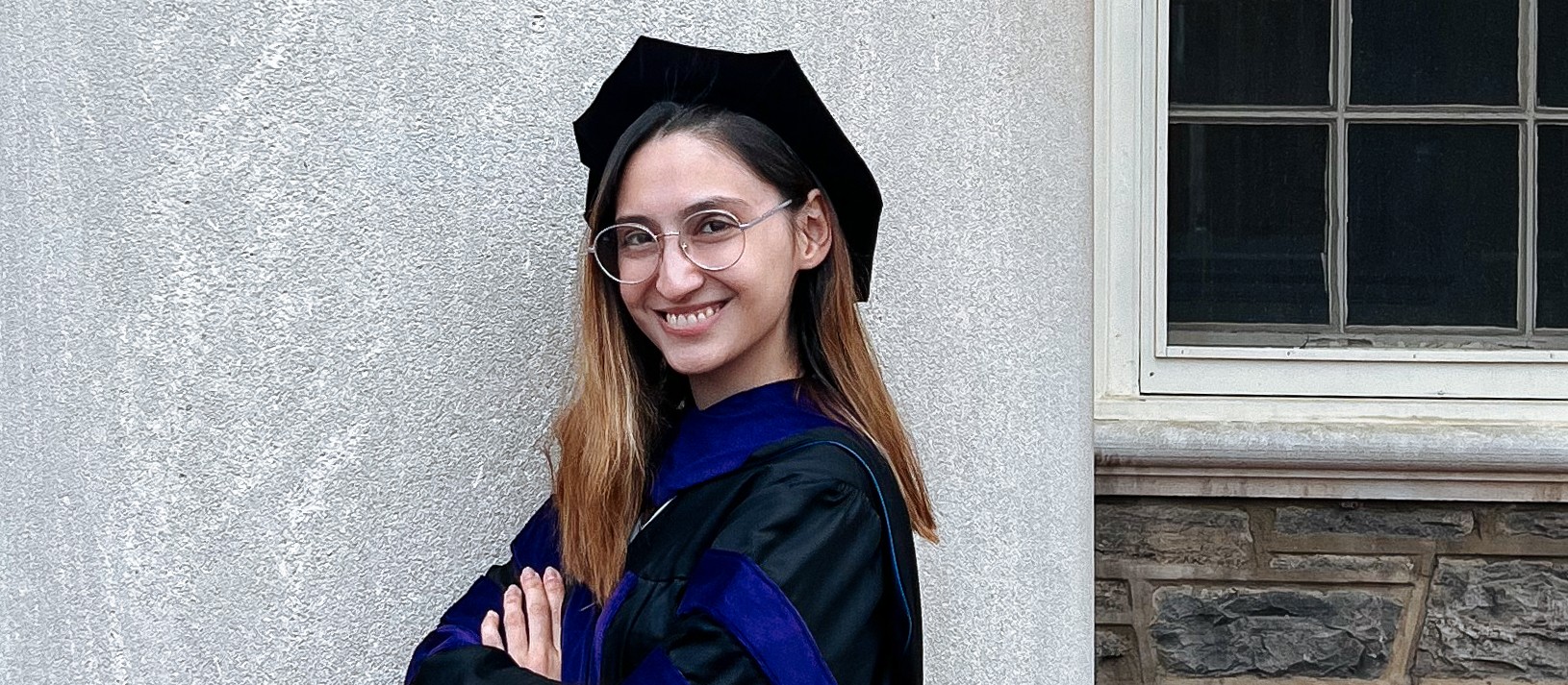 A woman in a cap and gown posing for a picture