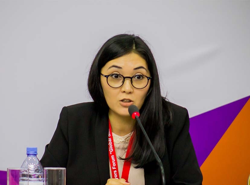 A woman sitting at a table with a microphone in front of her