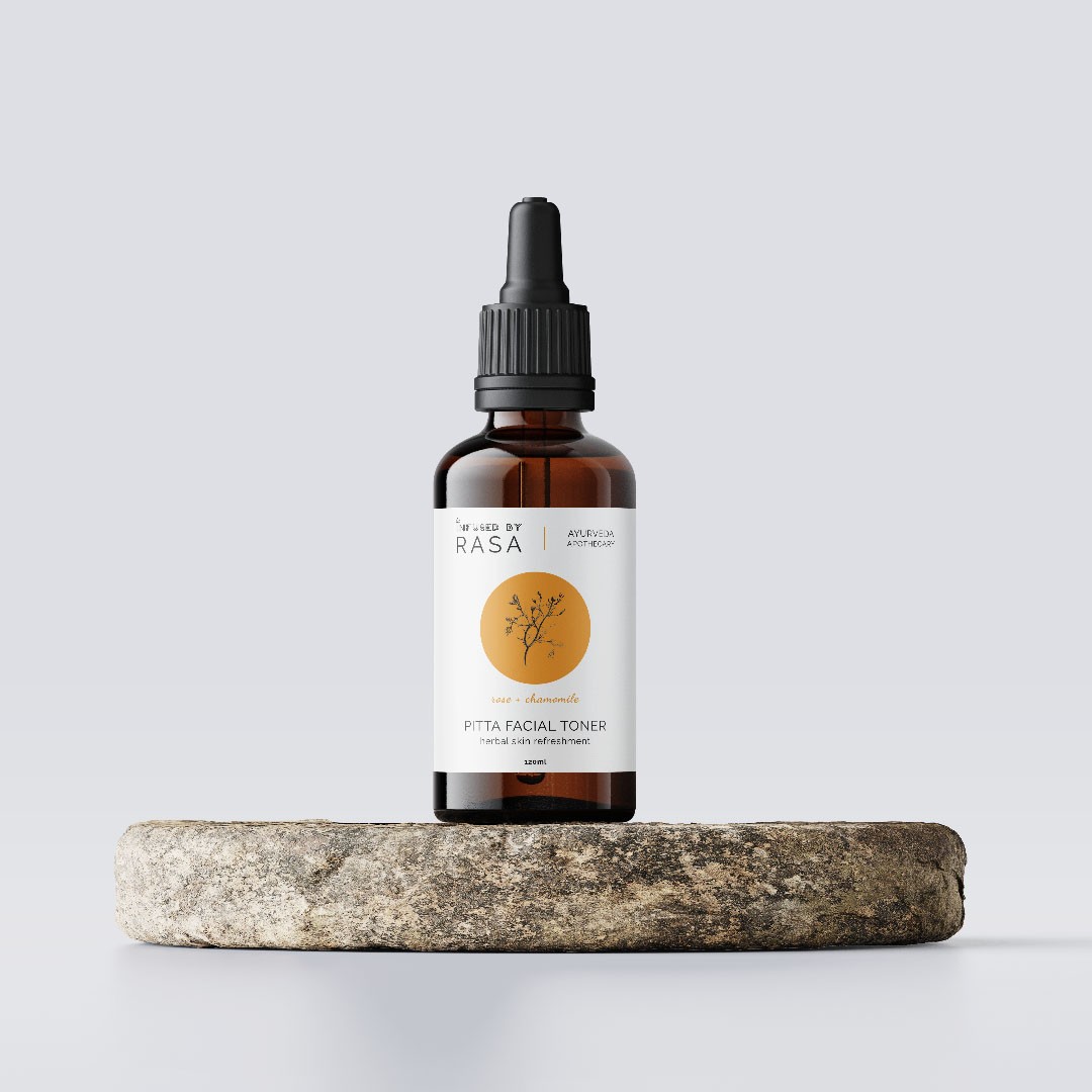 A bottle of liquid sitting on top of a rock