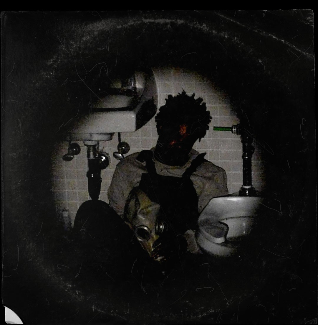 A man sitting in a bathroom next to a toilet